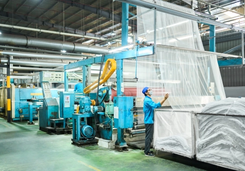 A man at Vestergaard manufacturing facility inspecting fabric used for mosquito nets
