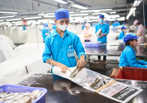 Worker in Vietnam putting a mosquito net in a package