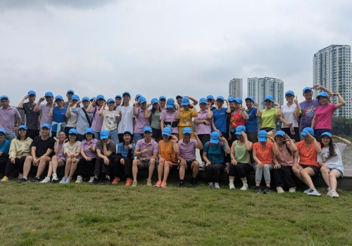 A group of people smiling with blue baseball caps