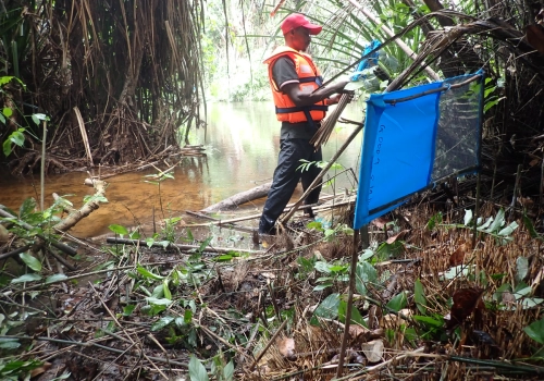 A man sets up a Tiny Target in a marsh
