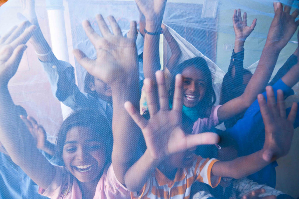 Indian children under a bed net